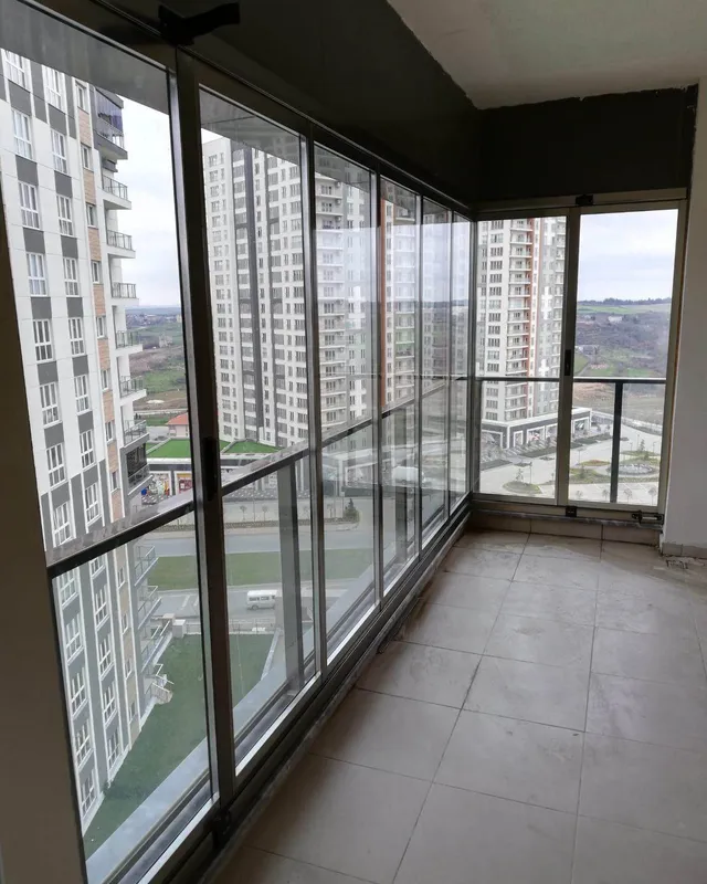 Yeni tamamlanmış konut balkonunda geniş şehir manzaralı sürme cam balkon uygulaması, saha fotoğrafı